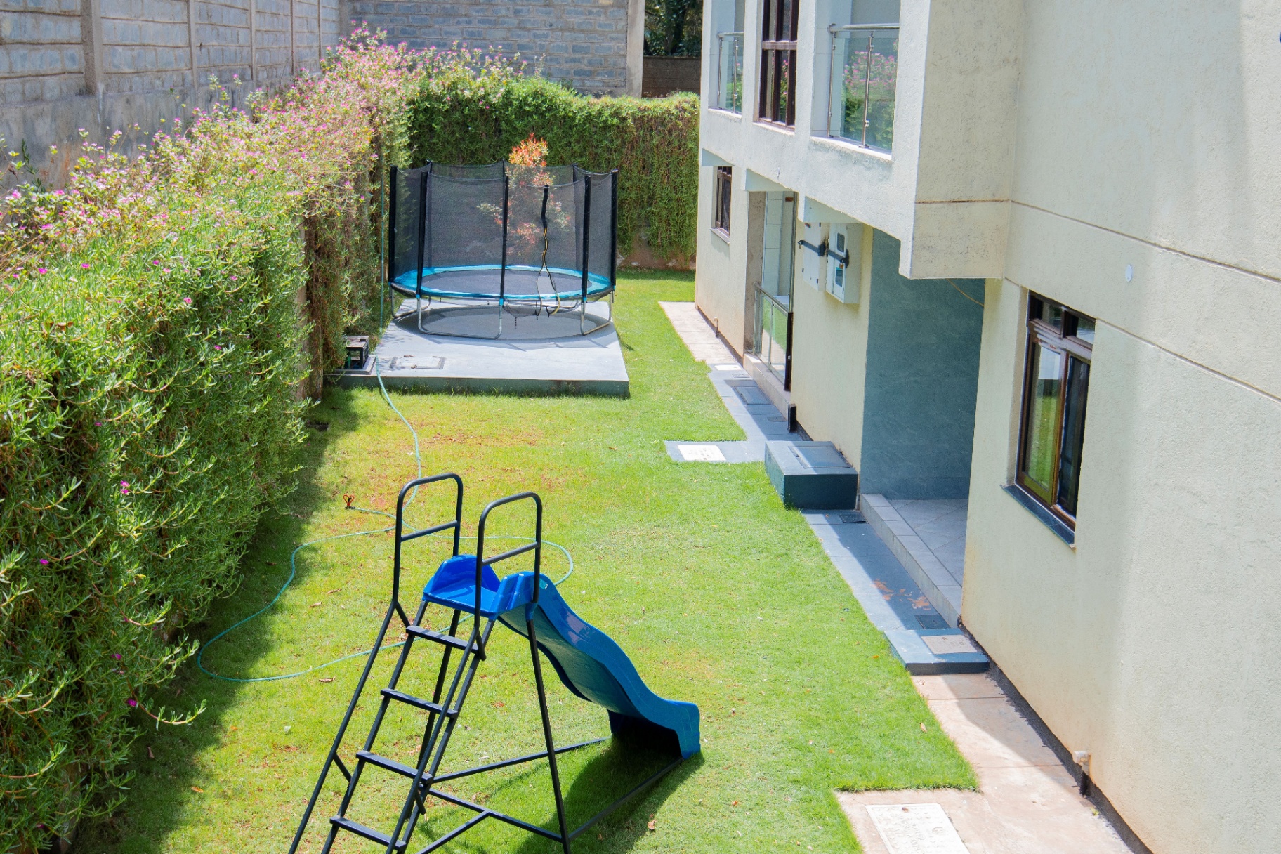 Garden play area with colorful slide and trampoline for children