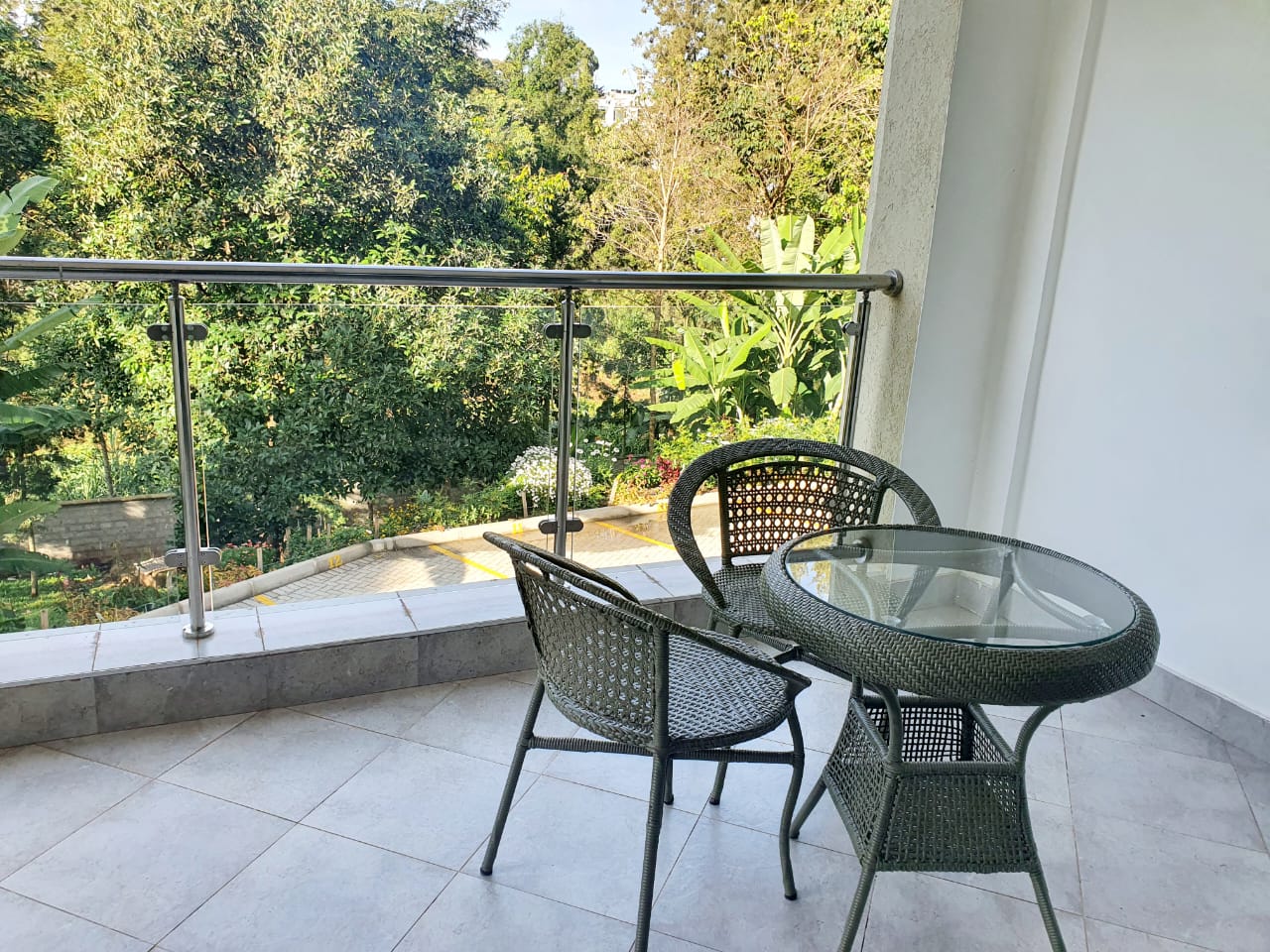 Private balcony with bistro set overlooking leafy greenery