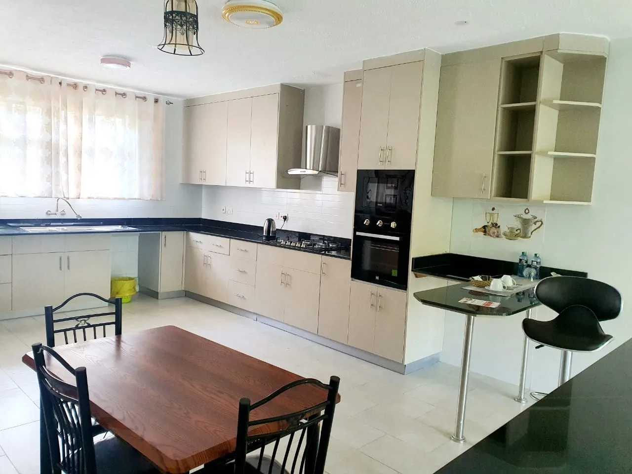 Contemporary open kitchen with breakfast bar and dining table; full-size appliances
