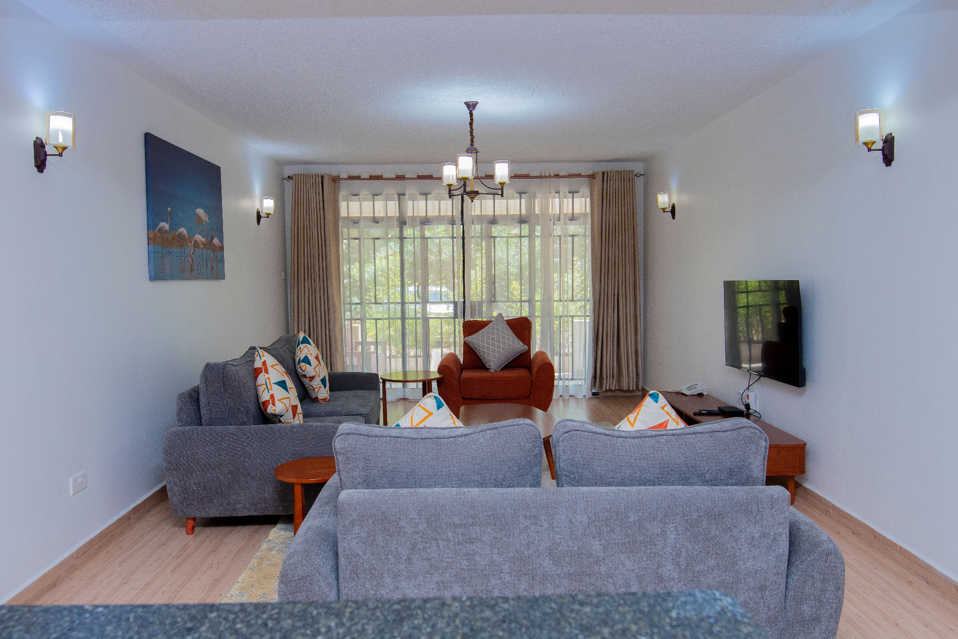 Two-Bedroom Furnished – living room with grey sofas, balcony light