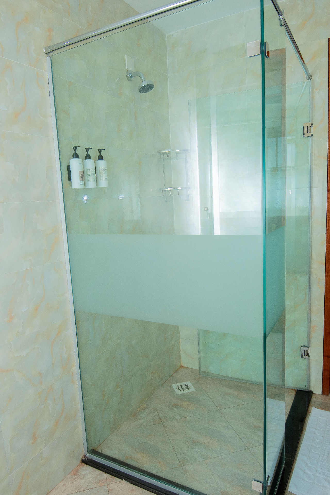 One-Bedroom Furnished – glass shower with mounted toiletries